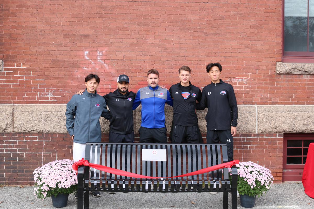 The UMass Lowell Men's Soccer Team behind the "Happy to Chat" Bench