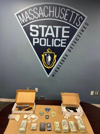 image of money, suspected narcotics and firearms pictured in front of a state police seal
