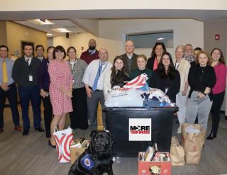 Middlesex staff pose with a bin of donated items