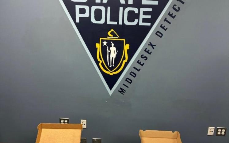Evidence Photo image of money, suspected narcotics and firearms pictured in front of a state police seal