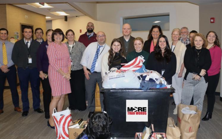 Middlesex staff pose with a bin of donated items